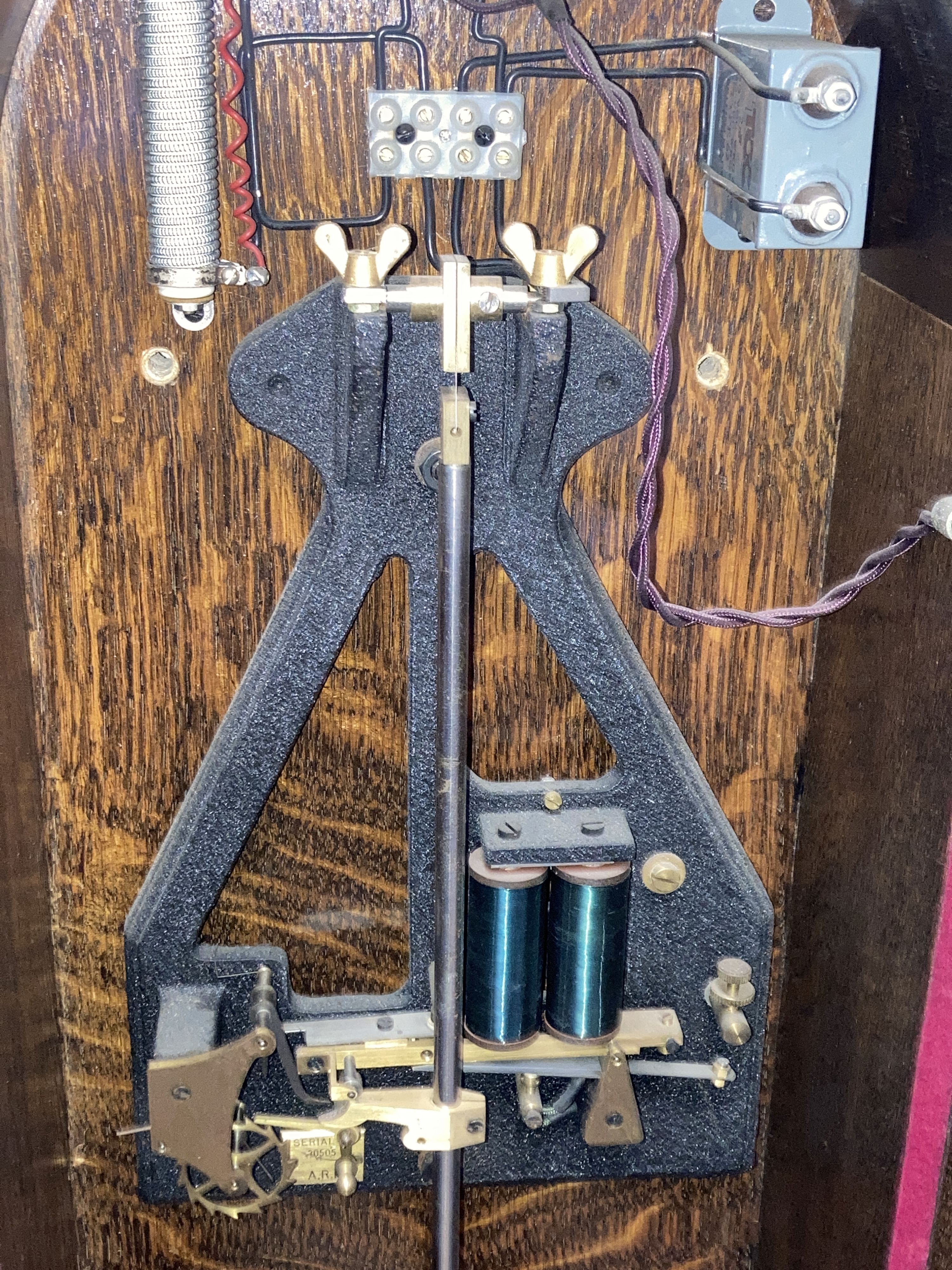 A Smiths English clock systems electric master clock in an arched oak case, with associated pendulum bob, marked ARN Serial No. 30505,